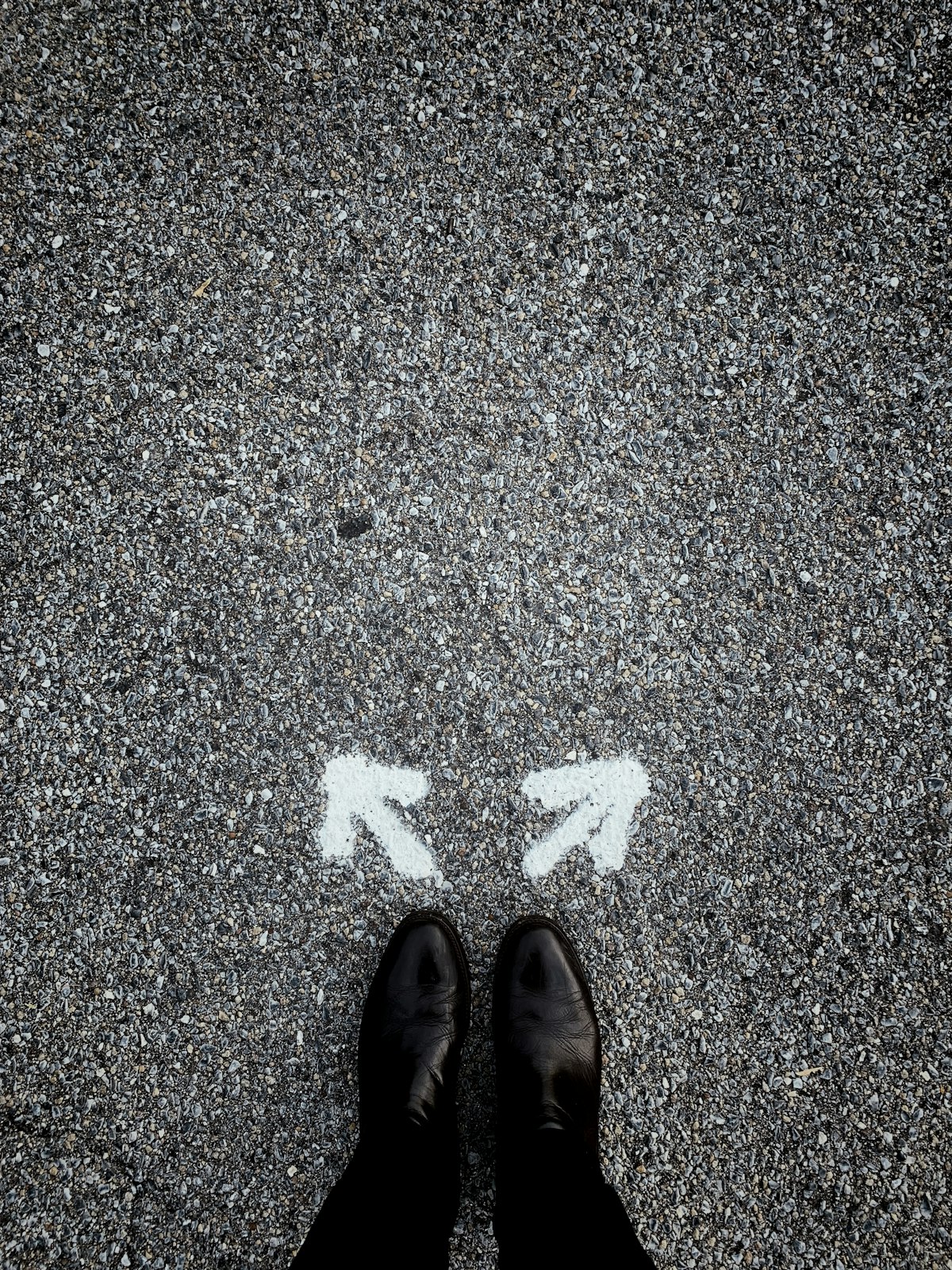 Pieds entre deux flèches directionnelles symbolisant le choix du statut social du dirigeant entre SAS et SARL