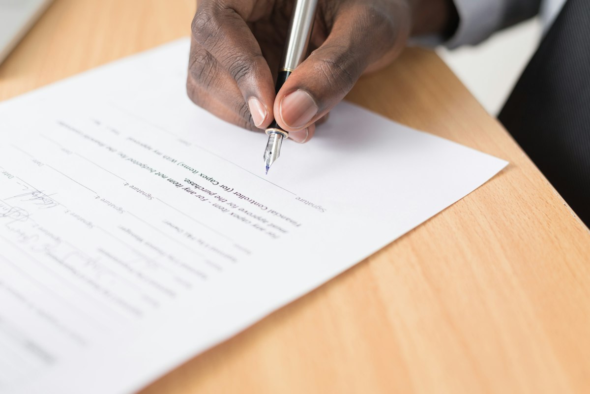 Personne écrivant sur papier, illustrant les bénéfices concrets d'une structure en holding