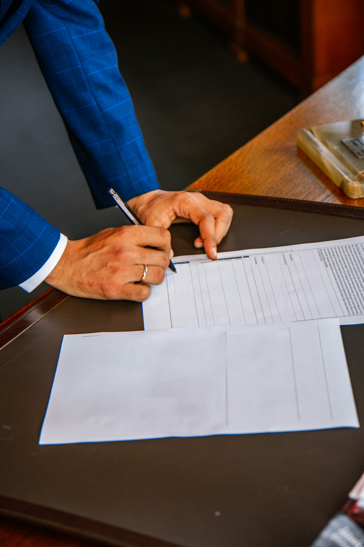Personne écrivant sur papier blanc, illustrant la transmission et la cession de titres