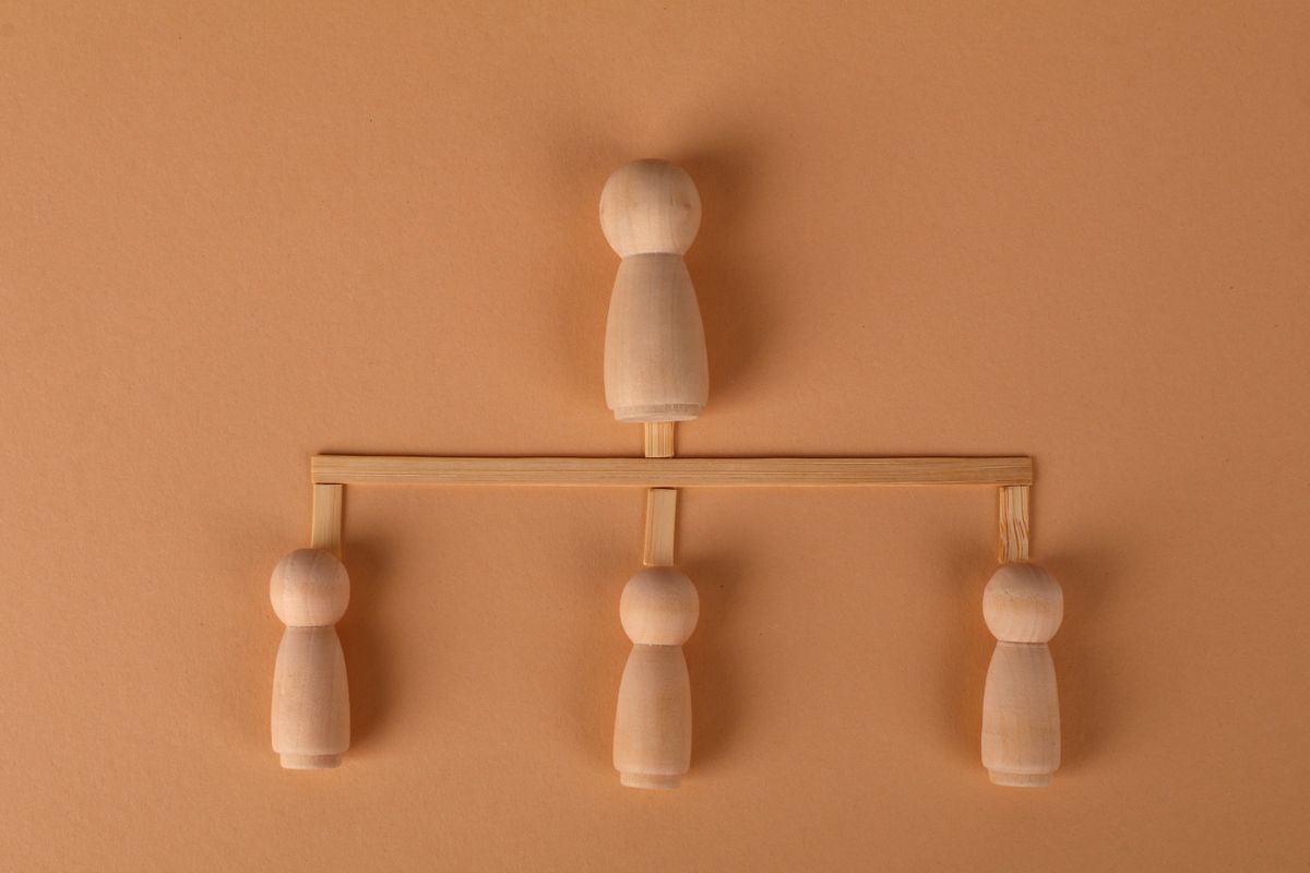 Figurines en bois représentant une structure familiale avec plusieurs héritiers