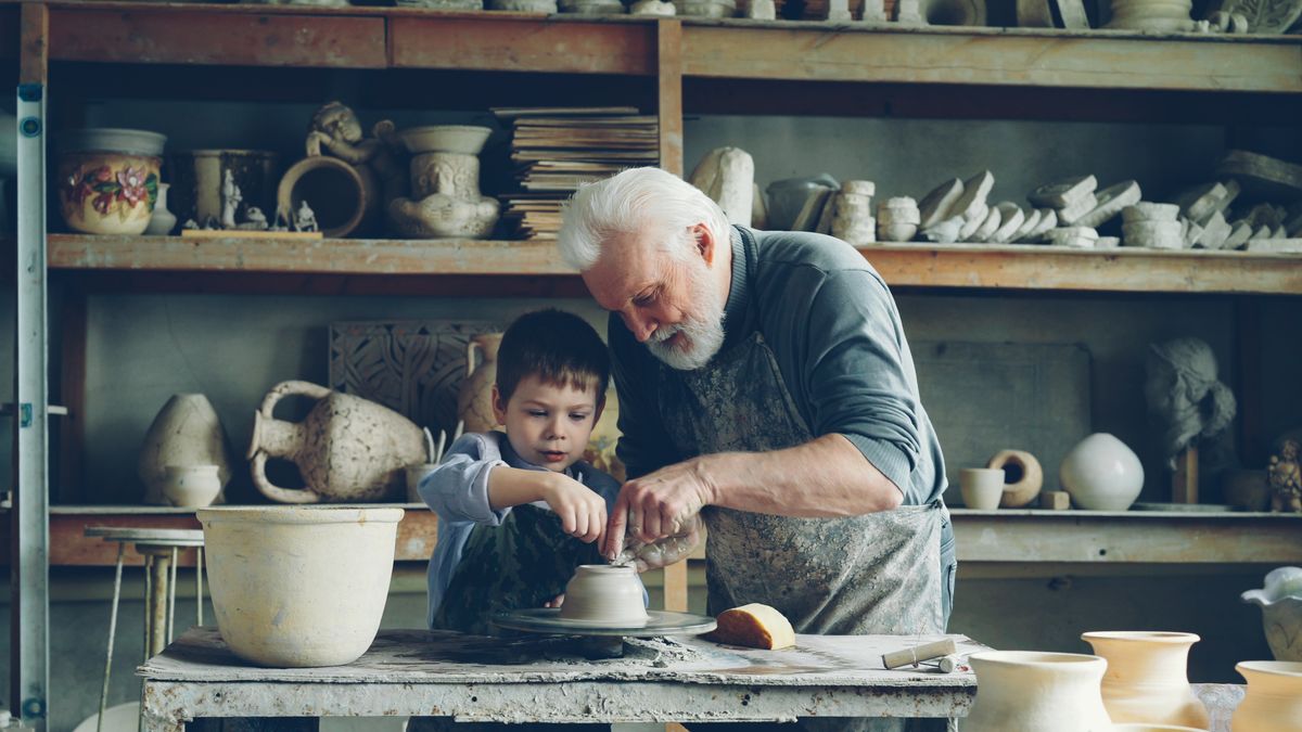 Un grand-père transmet son savoir-faire artisanal à son petit-fils dans un atelier