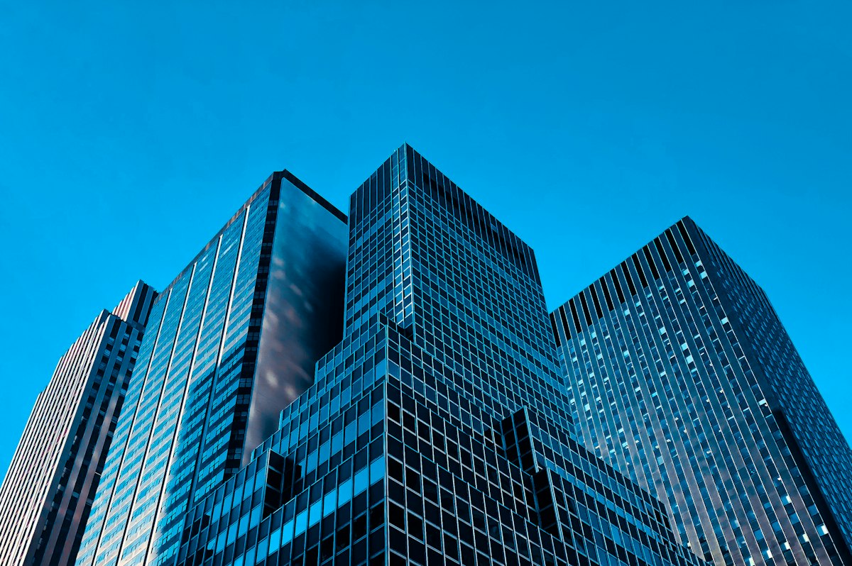 Vue en contre-plongée d'immeubles de grande hauteur illustrant les cas où créer une holding est pertinent
