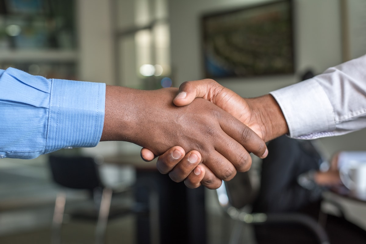Poignée de main entre deux associés scellant un accord, symbole de la signature d'un pacte d'associés